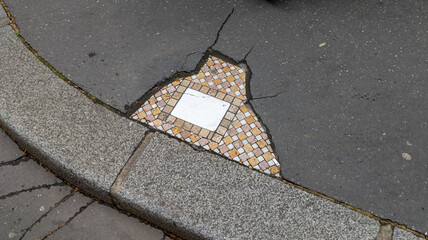 damaged and restored urban road sidewalk filled with tiles by an artist from Lyon city in France repaired with tiling mosaic street art