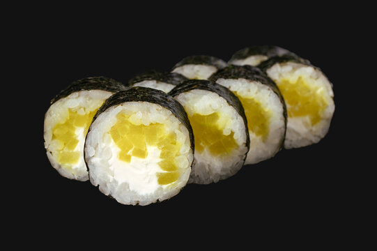 sushi roll with daikon and cream cheese isolated on black background.
