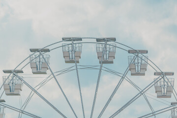Ferris wheel for panoramic view in amusement park is popular entertaining ride, shot against summer...