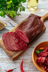 delicatessen meat with spices cut on a wooden board