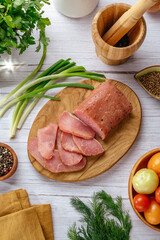 pork delicatessen meat with spices cut on a wooden board