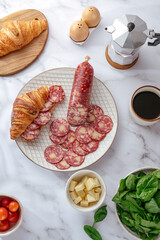 top view of the delicatessen spiced meat on a plate with croissant