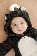 Baby smiling in skunk animal halloween costume