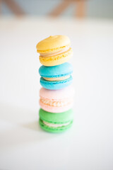 Colorful Macarons stacked up on a kitchen table