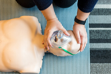 Woman performing CPR training dummy