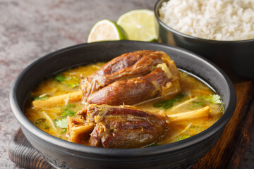 Nihari Pakistani lamb Shank Stew is a traditional slow-cooked one-pot meal made with meat in spicy gravy closeup on the wooden board on the table. Horizontal - obrazy, fototapety, plakaty