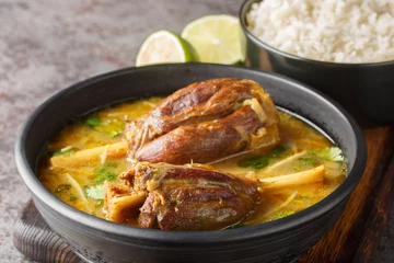 Poster Nihari Pakistani lamb Shank Stew is a traditional slow-cooked one-pot meal made with meat in spicy gravy closeup on the wooden board on the table. Horizontal © FomaA