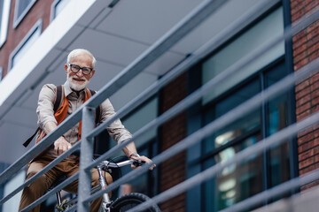 Elderly man, cyclist traveling through the city by bike. Senior city commuter riding a bike to...