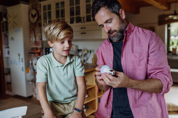 Father explaining led bubls to son, teaching him about energy efficiency, longevitiy and...
