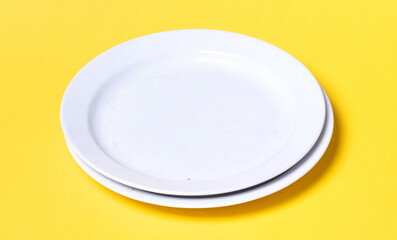 Two white plates on a solid background
