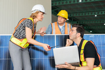 Team of engineers and architects working on a solar panel in a solar power plant.