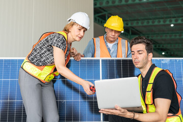 Team of engineers and architects working on a solar panel in a solar power plant.