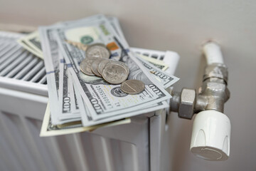 Radiator with dollar banknotes and coin cent as  expensive heating cost