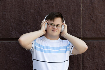 A boy with down syndrome listens to music in headphones