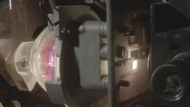 Closeup of the bulb of an 8mm projector that is on, shutter at 16 fps