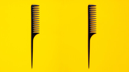 Black hair comb isolated on yellow background - obrazy, fototapety, plakaty
