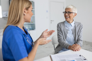 Obraz premium Senior woman, doctor and elderly patient with good news, tablet and results for health, advice and report. Happy medic, clipboard with smile, tech or support in hospital