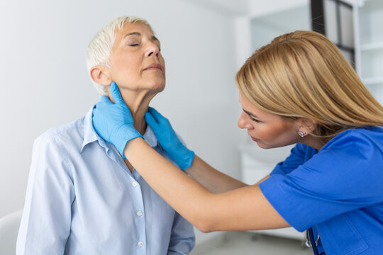 Endocrinologist examining throat of senior woman in clinic. Women with thyroid gland test . Endocrinology, hormones and treatment. Inflammation of the sore throat
