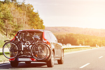 Transporting Bicycles by Car for a Vacation. A Vehicle with a Bike Carrier and a Rear Rack on the...