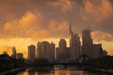 Low-hanging rain clouds surround Frankfurt's banking skyline and glow in the light of the setting evening sun., Osthafen, Frankfurt am Main, Hesse, Germany, Europe