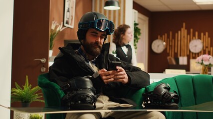 Person texting messages before skiing on mountain slopes, chatting with friends to have fun...