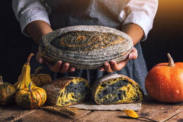 Homemade crusty sourdough bread oven baked and woman baker with autumn foods in kitchen