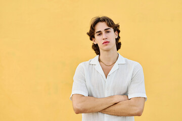 Proud young man standing serious with arms crossed