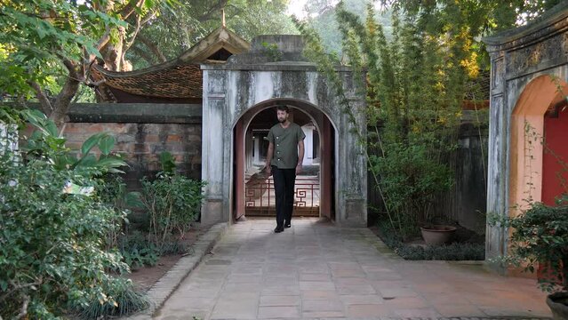Male model strolling through archway into garden photoshoot location