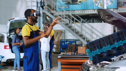 Repairman in car service using advanced virtual reality technology to visualize engine turbine in...