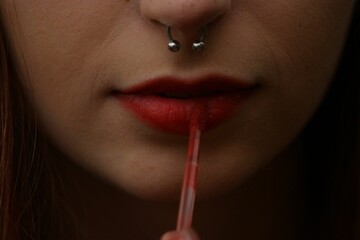 Young Caucasian woman applying lipstick