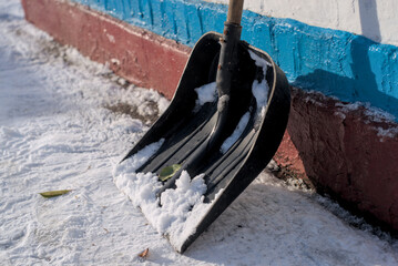 Black plastic shovel and first snow