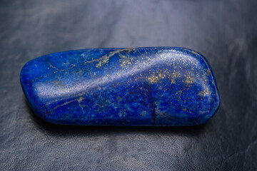 Lapis lazuli niebieski kamień izolowany na ciemnym tle - obrazy, fototapety, plakaty