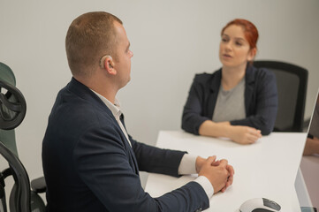 Business partners communicate in sign language. A deaf boss gives a task to a subordinate woman.