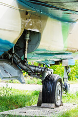 The chassis of an old military aircraft. Wheels and mechanism of a heavy fighter. Close-up. Vertical photo