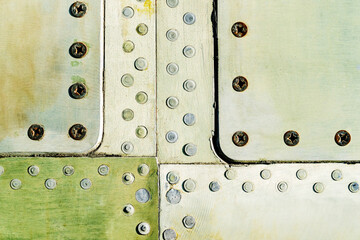 Duralumin panels with rivets and screws. Old skin of a military aircraft. Flat lay of the frame. Metal background