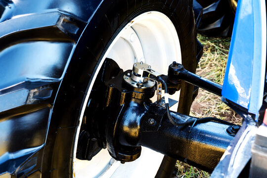 A fragment of a tractor wheel and steering mechanism. Close-up