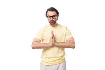 Fototapeta premium young handsome european brunette guy with a beard and mustache in glasses folded his hands together