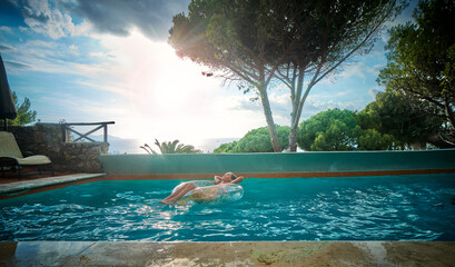 Girl with inflatable swim ring relaxing in pool
