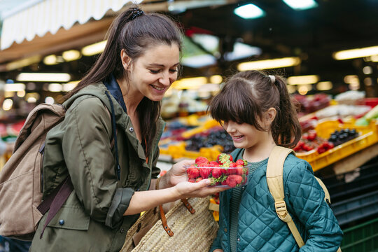 Mother and daughter shopping for fresh fruits and vegetables at the city market