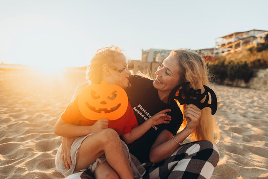 Happy mother and daughter enjoying together with Halloween toys at beach