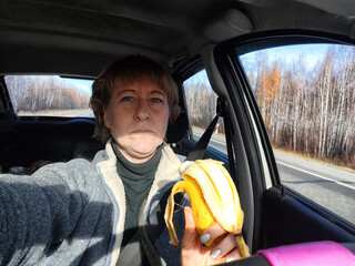 Portrait of female driver in solo journey. Adult mature middle aged woman holding steering wheel...