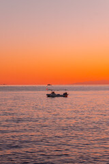 Naklejka premium 夕焼けの海に浮かぶ船