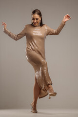 Glamorous female model in dress with sequins posing in studio. Full length portrait - 684522536