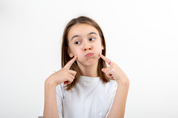 Girl touches her face and smiles on a white background isolated.