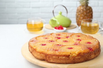 Tasty pineapple cake with cherries on white table. Space for text