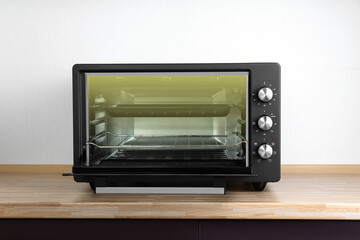 One electric oven on wooden table indoors