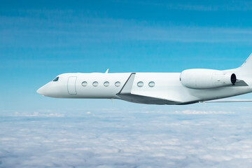 Naklejka na ściany i meble White modern luxury executive business jet flies in the air above the clouds