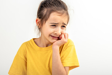 Scared and anxious girl, biting her fingernails on a white background isolated.