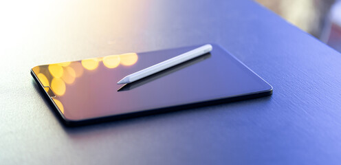 Digital tablet and stylus pen on the table close-up.