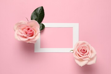 Empty frame and beautiful roses on pink background, top view. Space for text